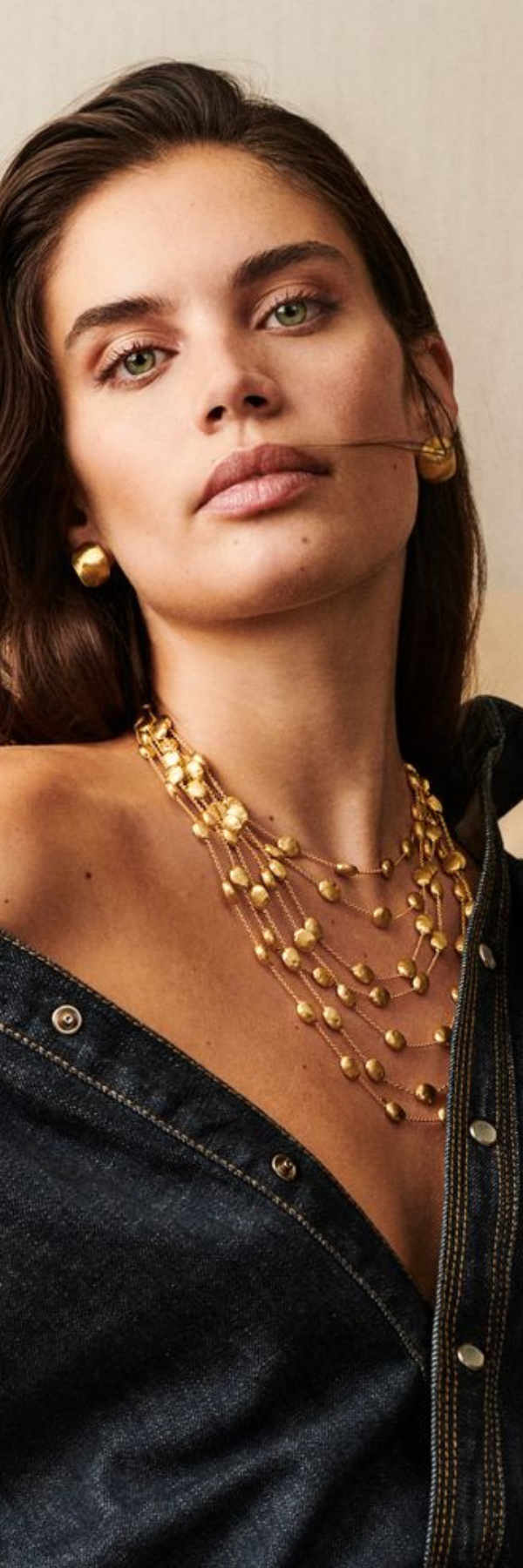 Marco Bicego model wearing gold earrings and necklace